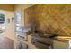 Outdoor kitchen with stainless steel grill, sink, storage and tiled backsplash at 7550 Gathering Dr, Reunion, FL 34747