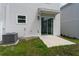 Backyard with sliding glass doors, patio, small yard and AC unit on a white home's exterior at 7728 Stone Creek Trl, Kissimmee, FL 34747