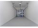 A clean, empty garage with gray flooring and white walls offers ample space for parking and storage at 7728 Stone Creek Trl, Kissimmee, FL 34747
