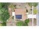 Aerial view of a home featuring solar panels on the roof, plus a backyard firepit and well-kept landscaping at 906 Elm Forest Dr, Minneola, FL 34715