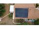Aerial view of a home featuring solar panels on the roof and surrounded by lush landscaping and green space at 906 Elm Forest Dr, Minneola, FL 34715