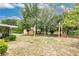 Expansive backyard featuring mature trees, string lights, a fire pit, a shed, and ample green space at 906 Elm Forest Dr, Minneola, FL 34715