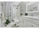 Well-lit bathroom featuring white fixtures, decorative shower curtain, and stylish accents at 906 Elm Forest Dr, Minneola, FL 34715