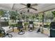 Relaxing covered patio with ceiling fan, comfortable chairs, and a serene backyard view at 906 Elm Forest Dr, Minneola, FL 34715