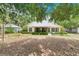 Charming home featuring a white roof, quaint screened-in porch, and lush greenery surrounding the property at 906 Elm Forest Dr, Minneola, FL 34715
