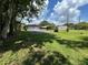 Expansive backyard showing the detached two-car garage and covered carport on a sunny day at 930 Aultman Rd, Kissimmee, FL 34744