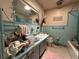 Retro bathroom features a blue tiled shower and countertop with speckled flooring at 930 Aultman Rd, Kissimmee, FL 34744