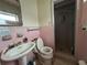 Pink retro bathroom features a single sink vanity and a shower stall with pink tiles at 930 Aultman Rd, Kissimmee, FL 34744