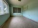 An empty bedroom has neutral colored terrazzo flooring and blue painted walls with two windows letting in natural light at 930 Aultman Rd, Kissimmee, FL 34744