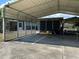 View of the carport and screened-in porch of the house with a metal roof and a trailer at 930 Aultman Rd, Kissimmee, FL 34744