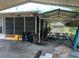 Open carport with a trailer and some containers next to the side of the home with screen windows at 930 Aultman Rd, Kissimmee, FL 34744