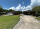 Home exterior featuring a driveway, garage, and carport at 930 Aultman Rd, Kissimmee, FL 34744