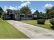 Charming single-story brick home with a covered parking area and well-maintained front lawn at 930 Aultman Rd, Kissimmee, FL 34744