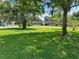 Sprawling front lawn with mature trees shading a single-story brick home on a sunny day at 930 Aultman Rd, Kissimmee, FL 34744