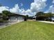 Spacious detached two-car garage and covered carport with a large grass area at 930 Aultman Rd, Kissimmee, FL 34744