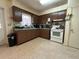 Well-lit kitchen features white appliances, lots of wooden cabinets and ample counter space at 930 Aultman Rd, Kissimmee, FL 34744