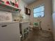 Functional laundry room featuring a utility sink, toilet, and ample shelving for storage solutions at 930 Aultman Rd, Kissimmee, FL 34744