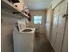 A laundry room features a white washing machine and sink, set in a practical space with shelving at 930 Aultman Rd, Kissimmee, FL 34744