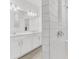 Modern bathroom showcasing dual sinks, white cabinetry, subway tile shower, and chrome hardware at 983 Silverlake Blvd, Lake Alfred, FL 33850