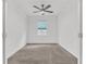 Cozy bedroom with a ceiling fan, plush carpeting, and natural light filtering through the window at 983 Silverlake Blvd, Lake Alfred, FL 33850