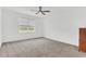Spacious bedroom with a ceiling fan, plush carpeting and natural light filtering through the window at 983 Silverlake Blvd, Lake Alfred, FL 33850