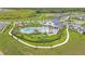 Aerial view of a community pool, playground and amenities with lush landscaping and green spaces at 983 Silverlake Blvd, Lake Alfred, FL 33850