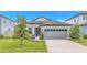 Charming single-story home featuring a well-manicured lawn, light gray siding, and a two-car garage at 983 Silverlake Blvd, Lake Alfred, FL 33850