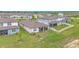 Aerial view of a home's rear exterior and lawn, featuring a screened patio and white picket fence at 983 Silverlake Blvd, Lake Alfred, FL 33850