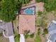 Aerial view of home with a screened-in pool, lush greenery, and mature landscaping at 1011 Dampierre Ct, Kissimmee, FL 34759