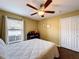 Inviting bedroom features a ceiling fan, wooden floors, and a view from the window complementing the white duvet cover at 1011 Dampierre Ct, Kissimmee, FL 34759