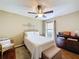 Cozy bedroom features a ceiling fan, wood floors, dresser, and a cushioned bench at the end of a neatly made bed at 1011 Dampierre Ct, Kissimmee, FL 34759