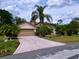 Charming home with a well-manicured lawn, palm trees, and a decorative driveway at 1011 Dampierre Ct, Kissimmee, FL 34759