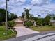 A charming single-story home with a well-manicured lawn, palm trees, and a patterned driveway at 1011 Dampierre Ct, Kissimmee, FL 34759