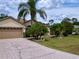 Charming single-story home with lush landscaping, a two-car garage, and a custom-patterned driveway at 1011 Dampierre Ct, Kissimmee, FL 34759