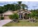 Charming single-story home with well-manicured lawn and mature palm trees at 1011 Dampierre Ct, Kissimmee, FL 34759