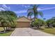 Attractive home with a spacious driveway, manicured lawn, and tropical landscaping at 1011 Dampierre Ct, Kissimmee, FL 34759