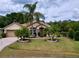 Attractive home with a lush lawn, mature palm trees, and a well-kept facade at 1011 Dampierre Ct, Kissimmee, FL 34759