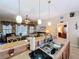 Open kitchen with pendant lighting, stainless steel sink, and eat-in counter overlooking the living area at 1011 Dampierre Ct, Kissimmee, FL 34759