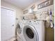 Functional laundry room with a washer and dryer, storage shelves, and a clean, organized layout at 1011 Dampierre Ct, Kissimmee, FL 34759