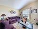 Bright living room with a high ceiling, purple sofa and stylish glass coffee table at 1011 Dampierre Ct, Kissimmee, FL 34759