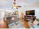 Comfortable living room featuring wood flooring, a ceiling fan, and an open layout leading to the kitchen at 1011 Dampierre Ct, Kissimmee, FL 34759