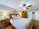 Comfortable main bedroom featuring a ceiling fan, bedside tables and lamps, and a private bathroom entrance at 1011 Dampierre Ct, Kissimmee, FL 34759