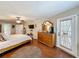Brightly illuminated main bedroom with wood floors, ceiling fan, mounted TV and private access to the backyard at 1011 Dampierre Ct, Kissimmee, FL 34759