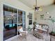 Relaxing patio with wicker furniture, decorative accents, and a view of the screened pool area at 1011 Dampierre Ct, Kissimmee, FL 34759