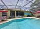 Private screened-in pool area, complete with patio furniture, a grill, and a mural at 1011 Dampierre Ct, Kissimmee, FL 34759