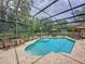 Sparkling screened-in pool with brick patio, waterfall feature, and outdoor seating at 1011 Dampierre Ct, Kissimmee, FL 34759
