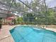 Beautiful in-ground screened pool with waterfall feature and outdoor seating areas at 1011 Dampierre Ct, Kissimmee, FL 34759