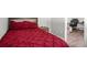Comfortable bedroom featuring a decorative wooden headboard and a striking red comforter set at 1024 Cohassett Ave, Lake Wales, FL 33853