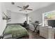 Bedroom featuring a ceiling fan, hardwood floors, two windows, a desk, and a TV at 1024 Cohassett Ave, Lake Wales, FL 33853