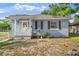 Charming exterior showcasing the white porch, complemented by black shutters and gray siding at 1024 Cohassett Ave, Lake Wales, FL 33853